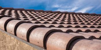 A closeup of a roof with a blue sky in the background.