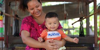 Cambodian homeowner Senghouch with her daughter Socheata in front of her weaving loom