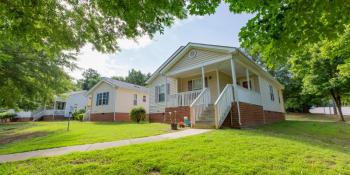 A row of houses with a bright green yard.