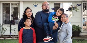 Family of five in front of home with Halloween decorations