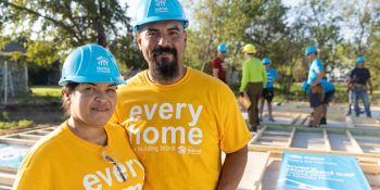 Habitat homeowners in hardhats on build site