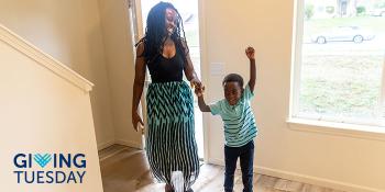 Mother walking into her new home with her young son jumping excitedly