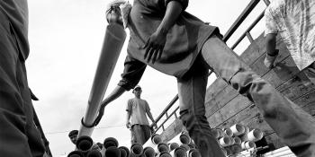 Workers unloading construction materials from barge in Banda Aceh Indonesia