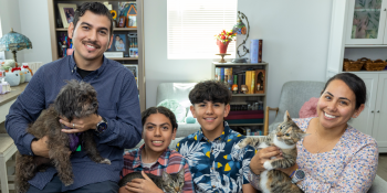Family sitting on couch with pets.