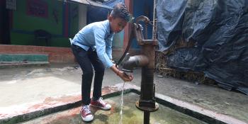 Nepali boy using hand pump