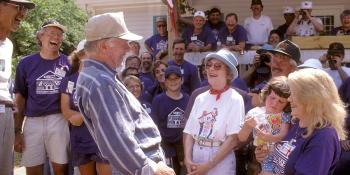 President Jimmy Carter and First Lady Rosalynn Carter laugh with a crowd.