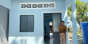 Vietnamese homeowner De in front of her home