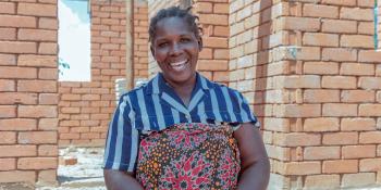 A lady standing in front of a house under construction