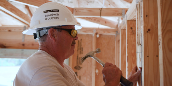 RV Care-A-Vanner volunteer hammers on the build site.