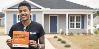 Homeowner in front of her Habitat house.