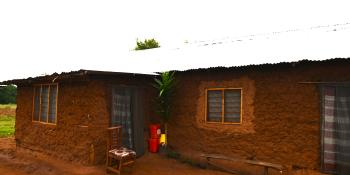 picture of a mud home with netting on windows and doors