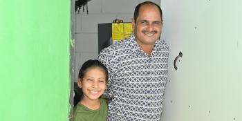 Un hombre y su hija en la puerta de una casa