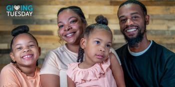 Mother and father smiling with their two young daughters
