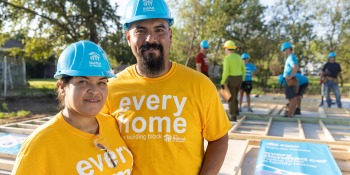 Habitat homeowners in hardhats at build site