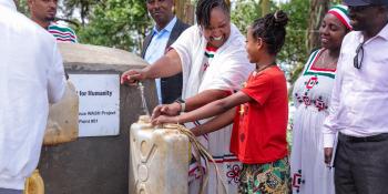 A group of people fetch water at a water point