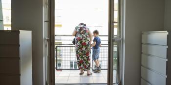 woman and child looking out on the balcony