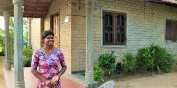 Thushanthini outside her home built with compressed stabilized earth blocks in Batticaloa, Sri Lanka