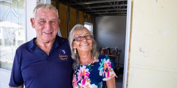 An older couple standing in a doorway together.