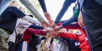 Japanese volunteers putting hands together for group photo