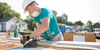 Volunteer measuring on build site. 