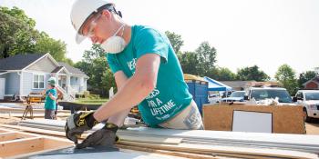 Volunteer measuring on build site.