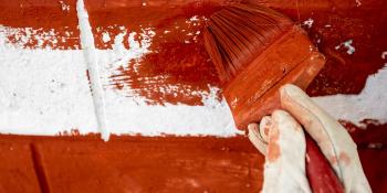 Close up of volunteer's hand painting a wall in Nepal