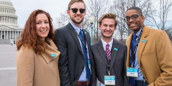 Four people standing together.