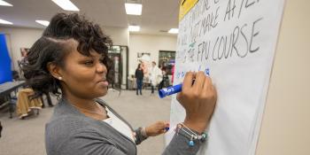 Woman writing on dry erase board during a financial training with Habitat for Humanity of Greater Nashville