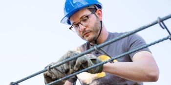 Man in hardhat on build site.