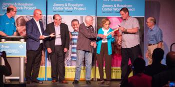 Carters hand off hammer on stage