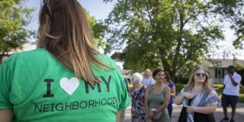 several neighbors congregating and a woman's shirt is prominent that says 'I love my neighborhood'