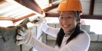 Woman in orange hardhat on a build site