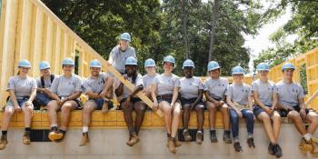 Large group of smiling AmeriCorps members on a build site
