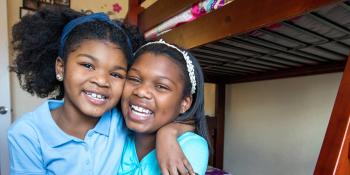 two girls smiling and hugging