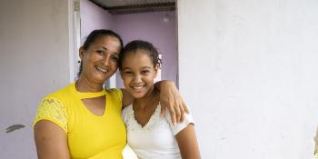 Mother and her adolescent daughter smiling and embracing
