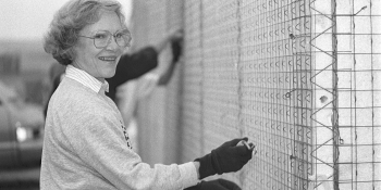 Black and white photo from 1990 of Rosalynn Carter smiling while working on the build site