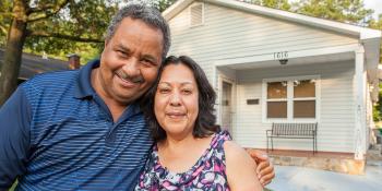 homeowner couple standing in front of house.