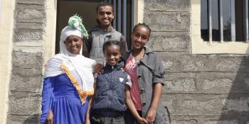 Ethiopian mother and her three children in front of their home.