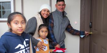 The Garcia family unlocking the door to their new Habitat home.