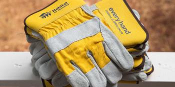 Close-up of yellow Habitat-branded work gloves on porch railing.