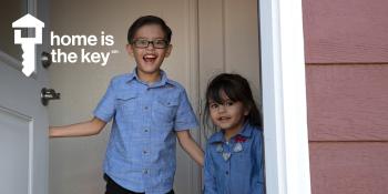 Young boy and girl in doorway of home