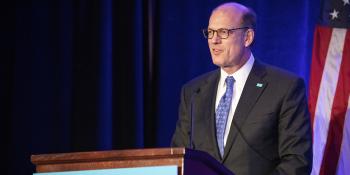 Habitat CEO Jonathan Reckford speaking at a podium.