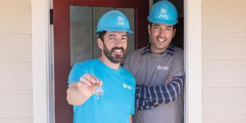Drew Scott holding keys next to Jonathan Scott in Habitat branded hard hats.