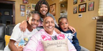 Woman surrounded by her three smiling grandchildren