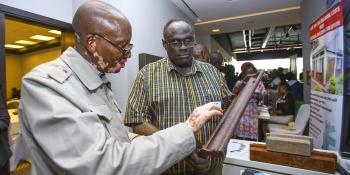 Two men looking at a ShelterTech participant prototype building material.