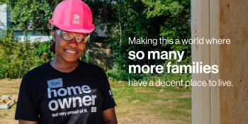 Habitat homeowner in hard hat, text reads "Making this a world where so many more families have a decent place to live."