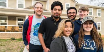 Group of six student volunteers smiling together