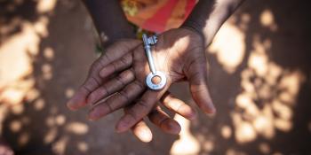 close up of the hands of a Zambian child holding a key.