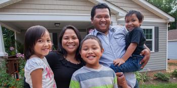 A family stands outside their home.