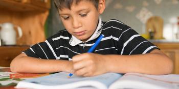 Young boy works on school work.